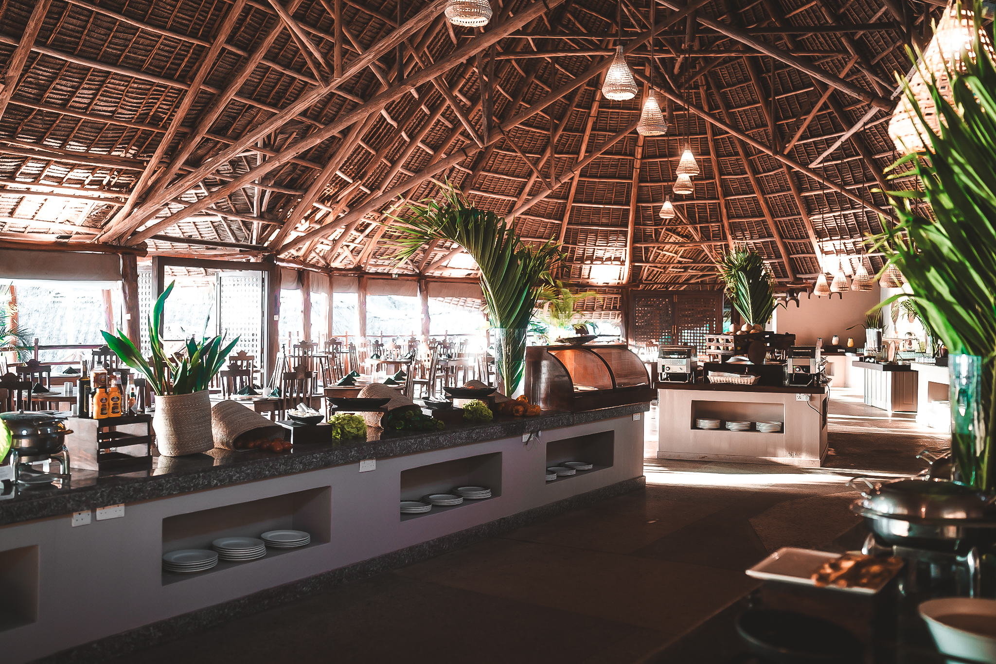 Großzügiges Restaurant mit traditionellem Makuti-Dach, reich gedecktem Buffet und stilvollen Dekorationen.